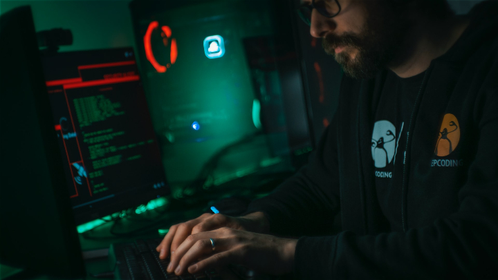 Man in black jacket using computer.